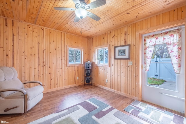 sitting room featuring a wealth of natural light, wooden ceiling, baseboards, and wood finished floors