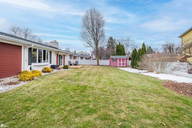 view of yard with central AC unit, a shed, an outdoor structure, and a fenced backyard