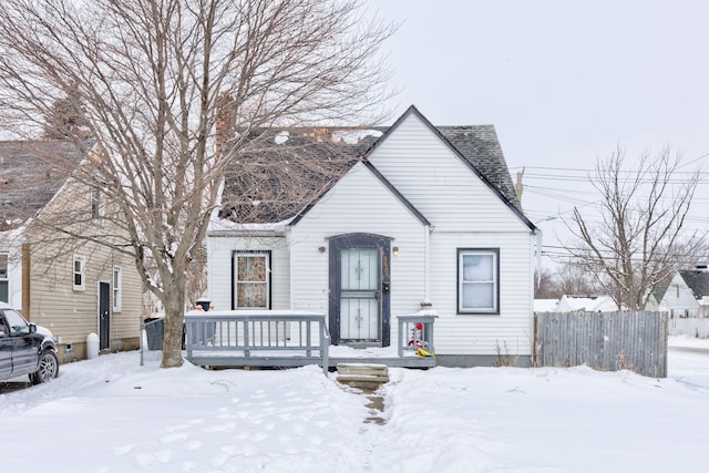 bungalow-style house featuring a shingled roof and fence