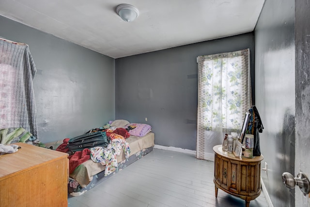 bedroom with baseboards and wood-type flooring