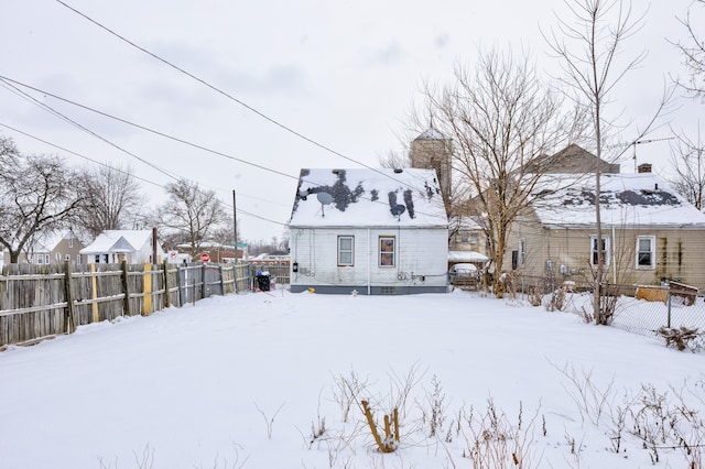 snow covered property with fence