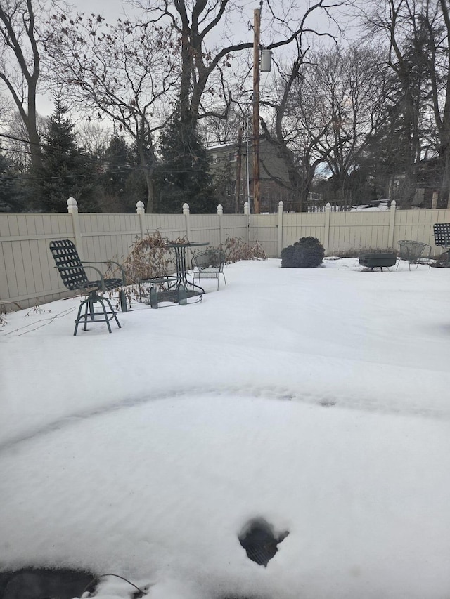 snowy yard featuring fence