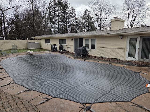 view of swimming pool featuring fence, grilling area, and a patio