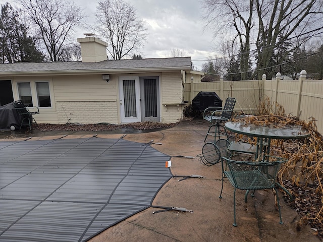 exterior space featuring grilling area, fence, and a fenced in pool