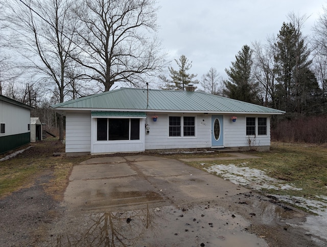 view of front of house featuring a chimney and metal roof