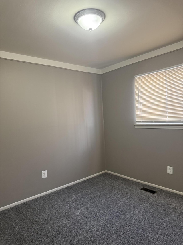 carpeted empty room featuring visible vents and baseboards