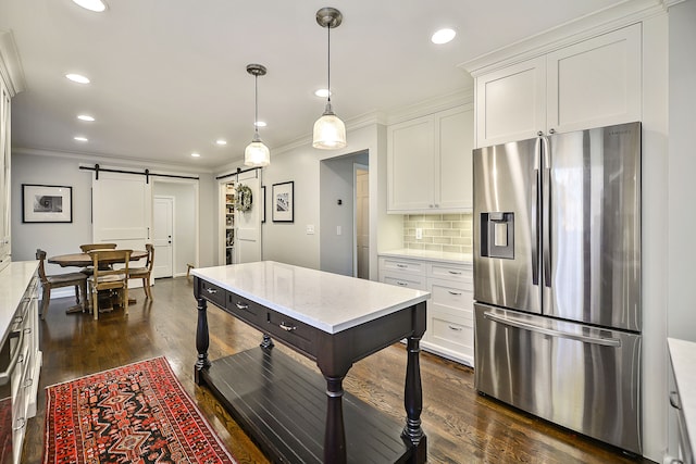 kitchen featuring ornamental molding, tasteful backsplash, a barn door, white cabinets, and stainless steel fridge with ice dispenser