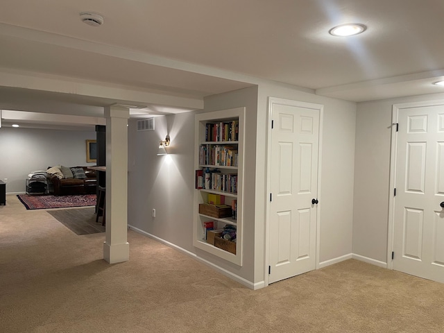 finished basement featuring visible vents, built in shelves, carpet, and baseboards