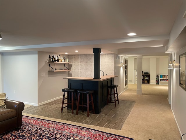 bar with recessed lighting, a bar, carpet, and baseboards