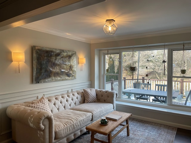 living area with a wainscoted wall and crown molding