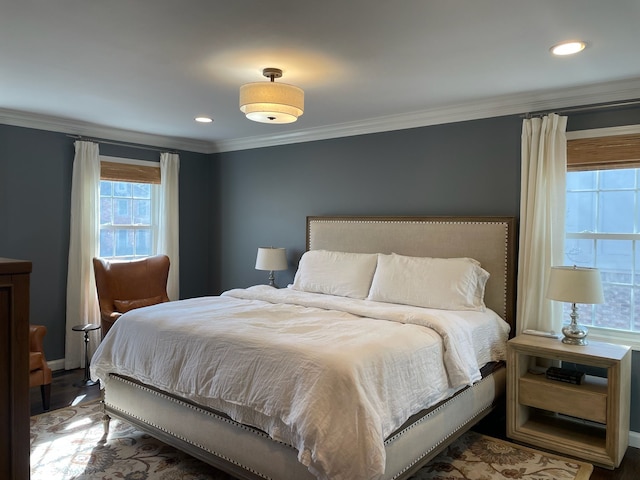 bedroom with wood finished floors and ornamental molding