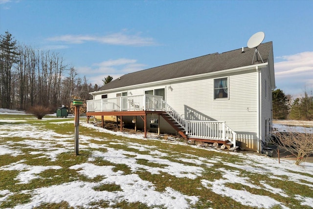 snow covered property featuring a deck and stairway