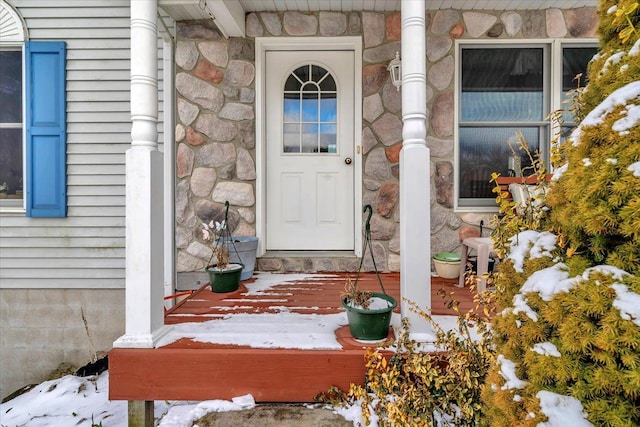 property entrance featuring stone siding and a porch