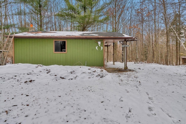 snow covered structure featuring an outdoor structure