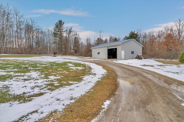 exterior space featuring a pole building and dirt driveway