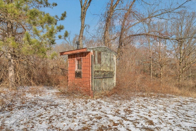 snow covered structure featuring an outdoor structure