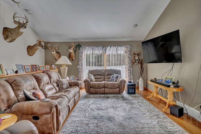 living room featuring wood finished floors and vaulted ceiling