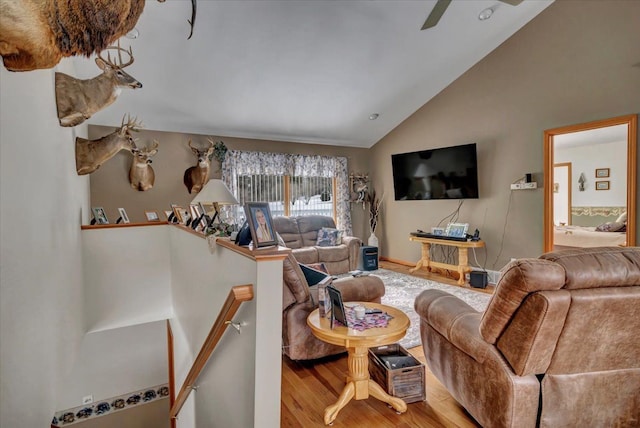 living area with wood finished floors and vaulted ceiling