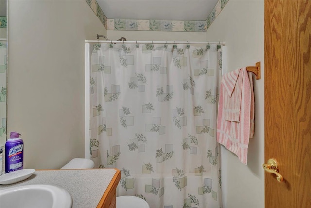 bathroom featuring a shower with shower curtain, toilet, and vanity