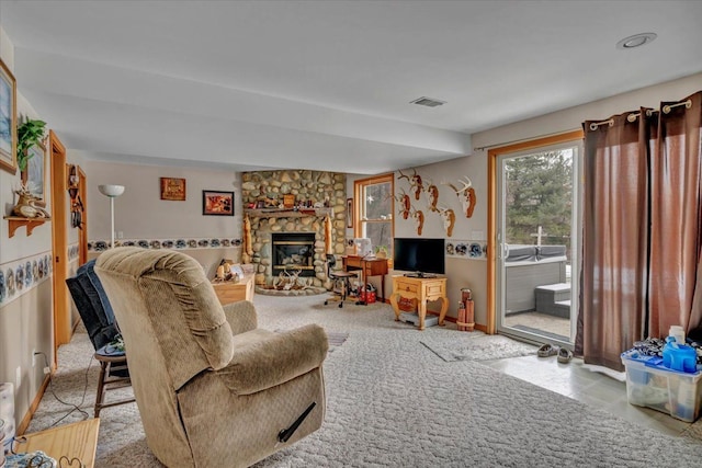 carpeted living area featuring visible vents and a stone fireplace