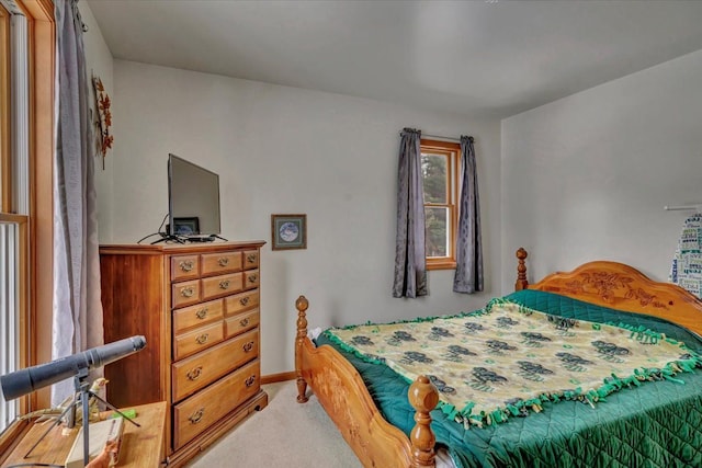 bedroom featuring baseboards and light carpet