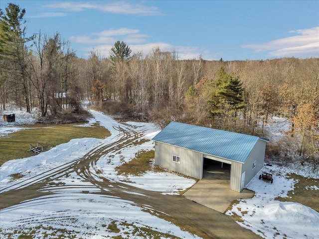 snowy aerial view featuring a forest view