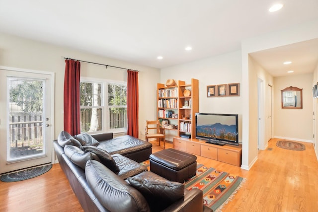 living room with a wealth of natural light, light wood-type flooring, baseboards, and recessed lighting