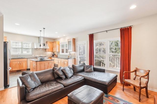 living room with recessed lighting, light wood-style flooring, and baseboards