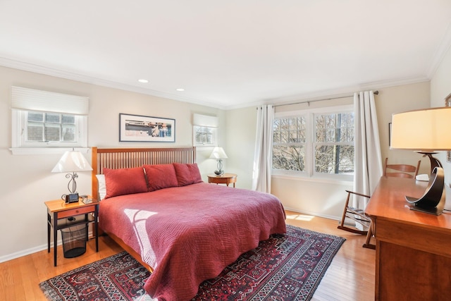 bedroom featuring crown molding, light wood-style flooring, and baseboards