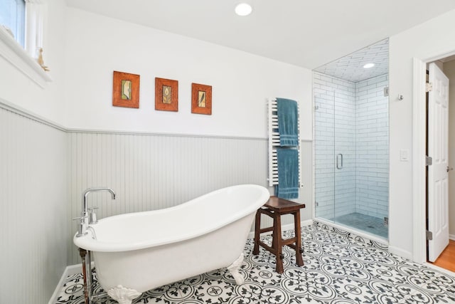 full bathroom featuring a freestanding bath, radiator heating unit, wainscoting, a shower stall, and tile patterned floors