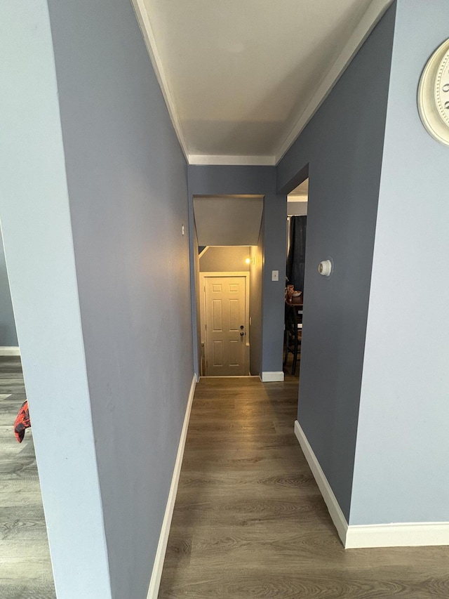 hall with crown molding, baseboards, and wood finished floors