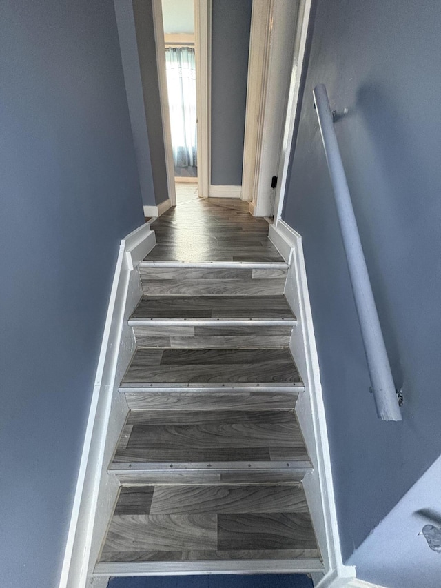 stairway featuring baseboards and wood finished floors