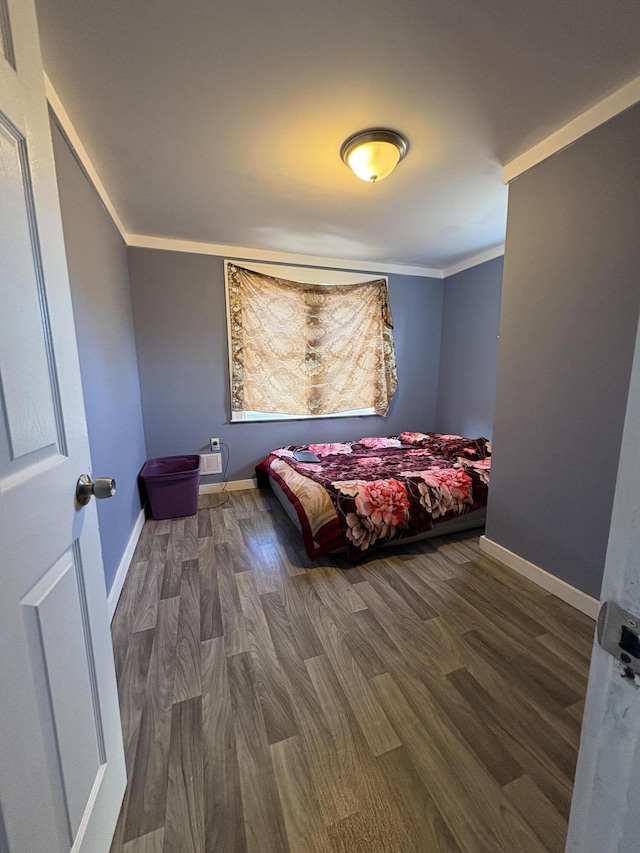 bedroom featuring crown molding, baseboards, and wood finished floors