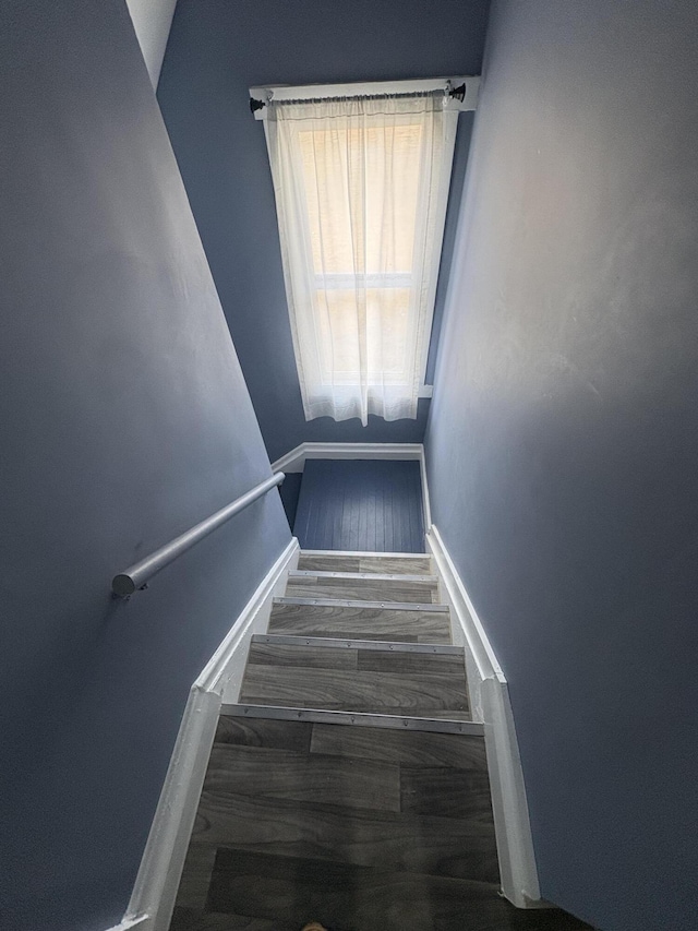 staircase with wood finished floors and baseboards