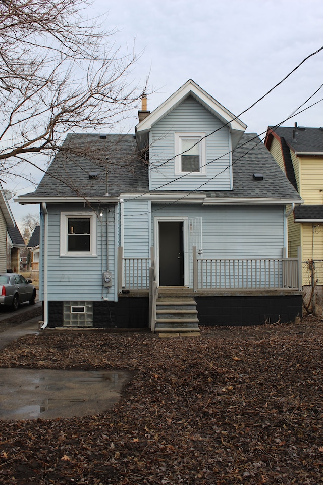 view of front of property featuring a shingled roof, entry steps, and a chimney