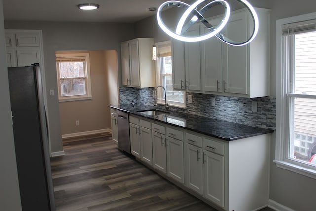 kitchen with stainless steel appliances, tasteful backsplash, a sink, and a wealth of natural light