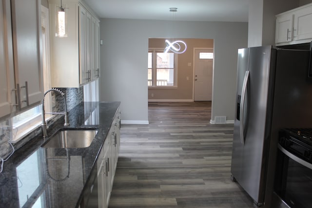 kitchen with wood finished floors, visible vents, a sink, baseboards, and range