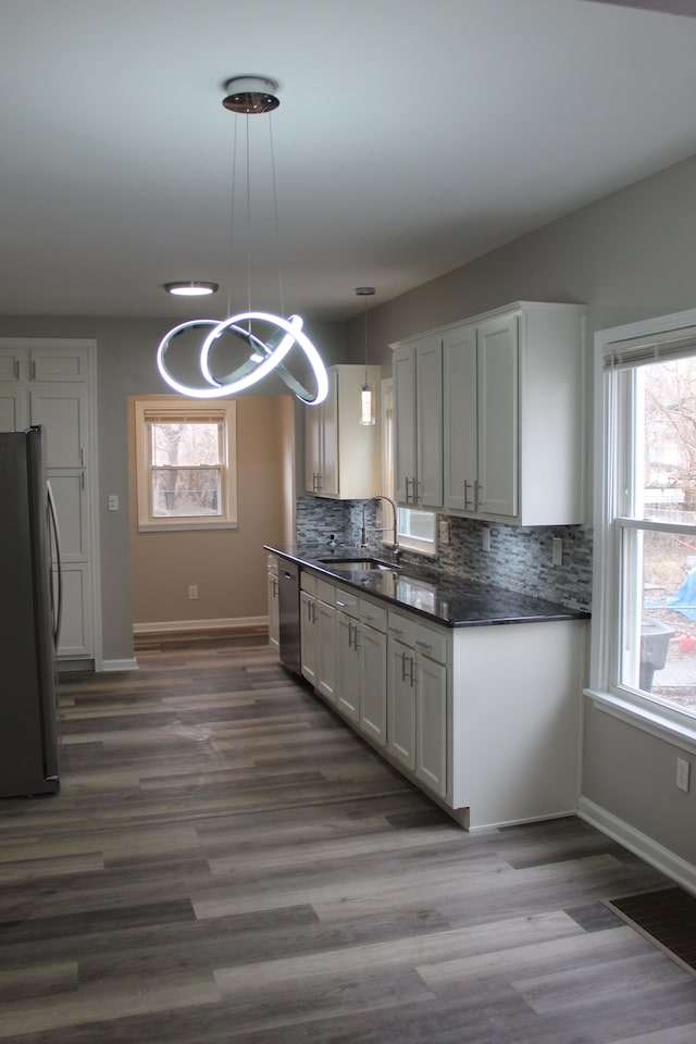 kitchen with a healthy amount of sunlight, tasteful backsplash, appliances with stainless steel finishes, and a sink