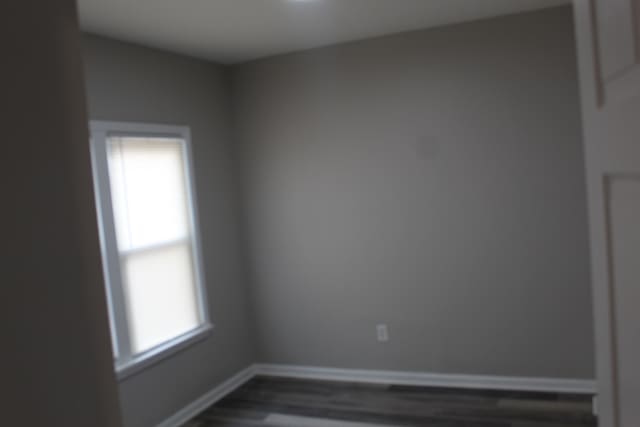 unfurnished room with dark wood-style floors and baseboards