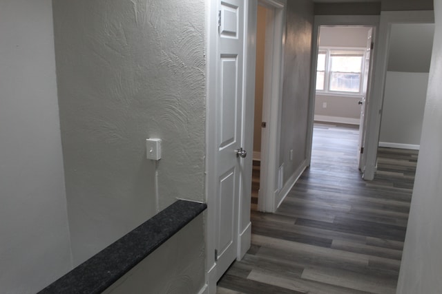 hall featuring baseboards and wood finished floors