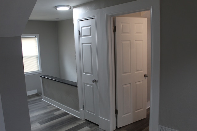 hall with baseboards and dark wood-type flooring