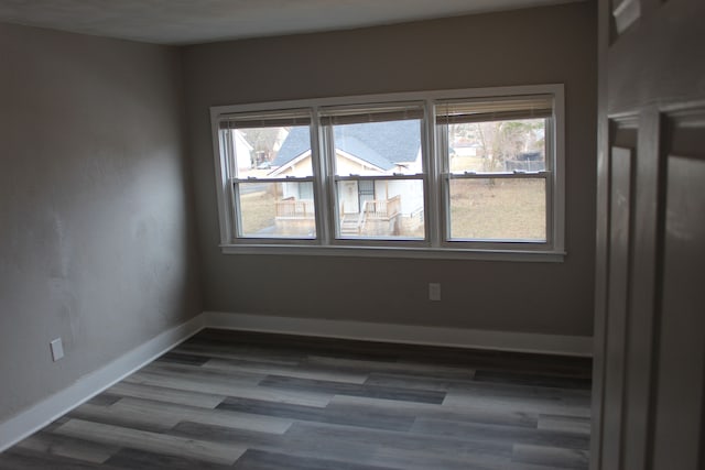 spare room with dark wood-style floors and baseboards