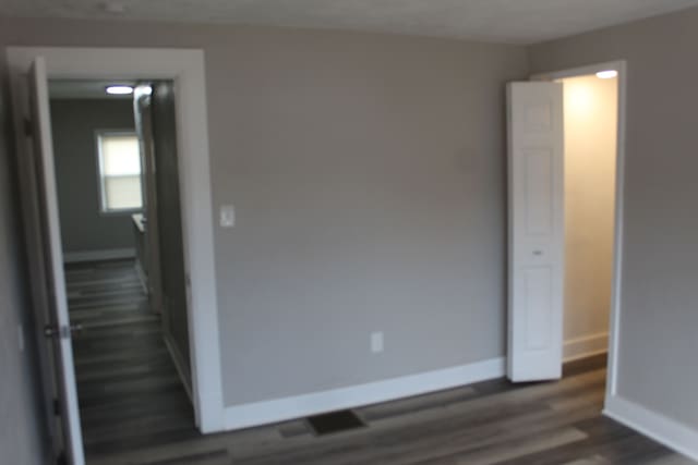 interior space featuring dark wood-style floors and baseboards