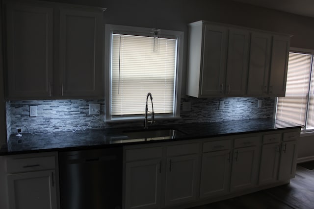 kitchen featuring a sink, dark countertops, decorative backsplash, and dishwasher