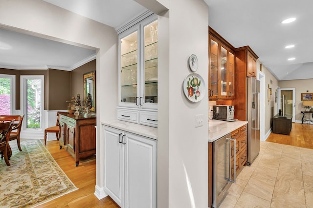 bar with ornamental molding, recessed lighting, stainless steel fridge, and light wood-style flooring