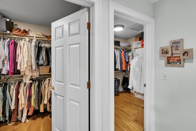 spacious closet with wood finished floors and attic access