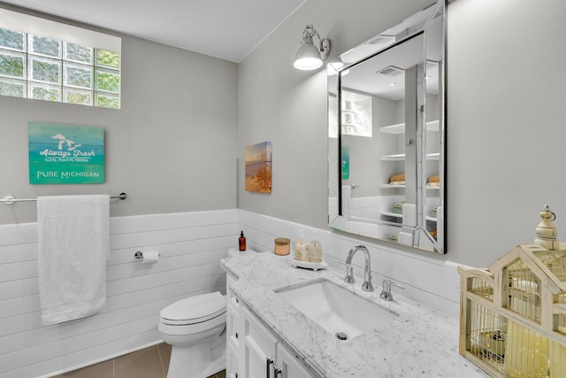 bathroom featuring visible vents, wainscoting, vanity, and toilet