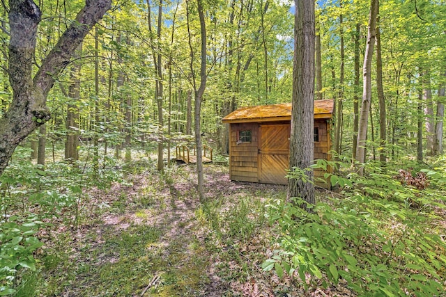 view of shed with a wooded view