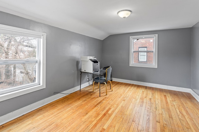 home office with lofted ceiling, plenty of natural light, baseboards, and hardwood / wood-style floors