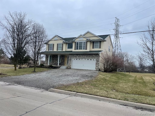 traditional-style home with stone siding, a front lawn, an attached garage, and driveway